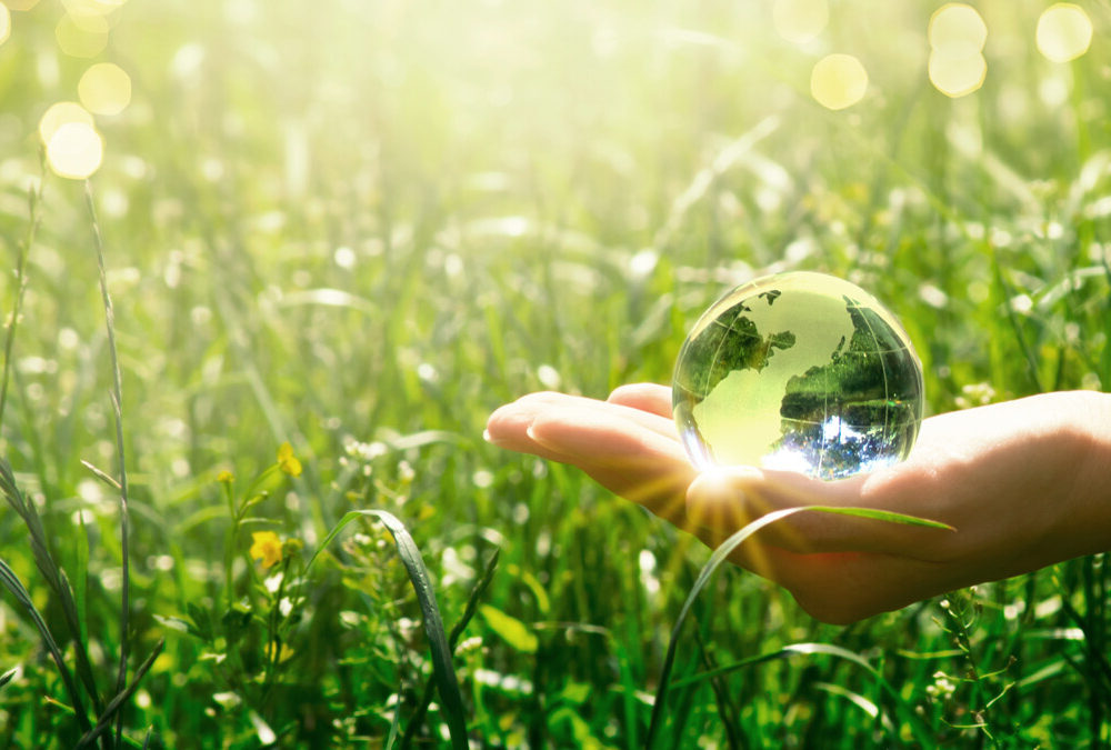 Hand holding a glass ball catching the sun