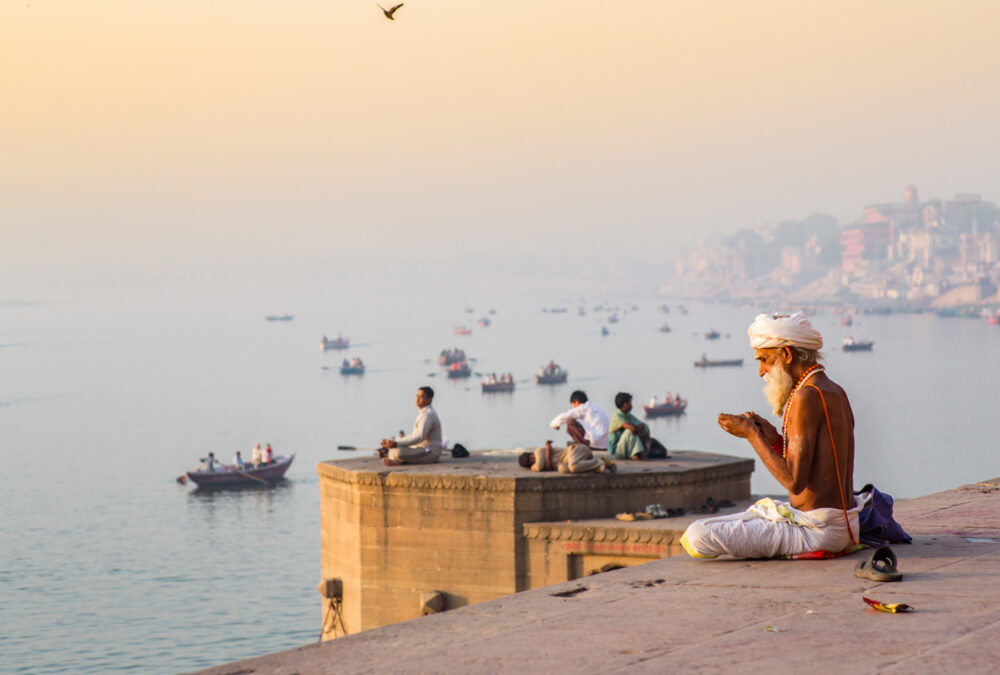 Elderly man sitting on a raised sea wall